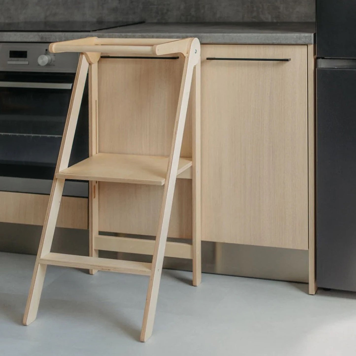 Foldable toddler tower unfolded and ready for use, showcasing natural wood finish and practical design by Roomix