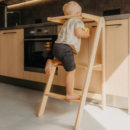 Roomix foldable toddler learning tower folded flat, emphasizing easy portability and space-saving design