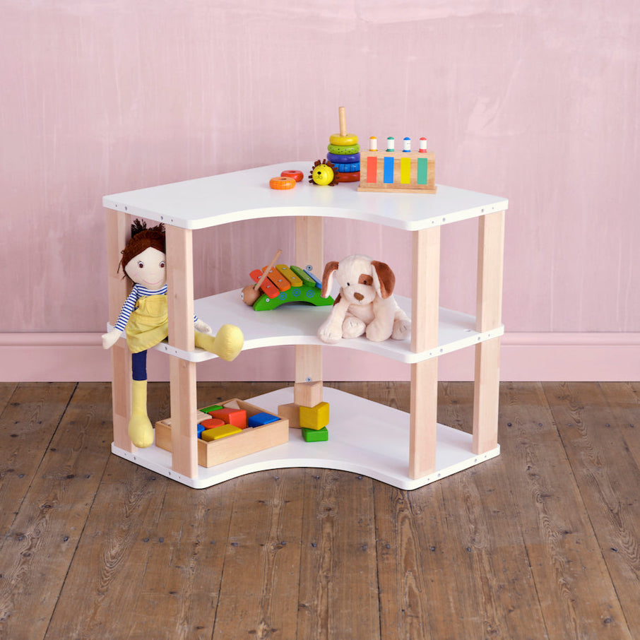 Wide shot of Montessori corner shelves filled with educational toys and books in a cozy kids' learning space