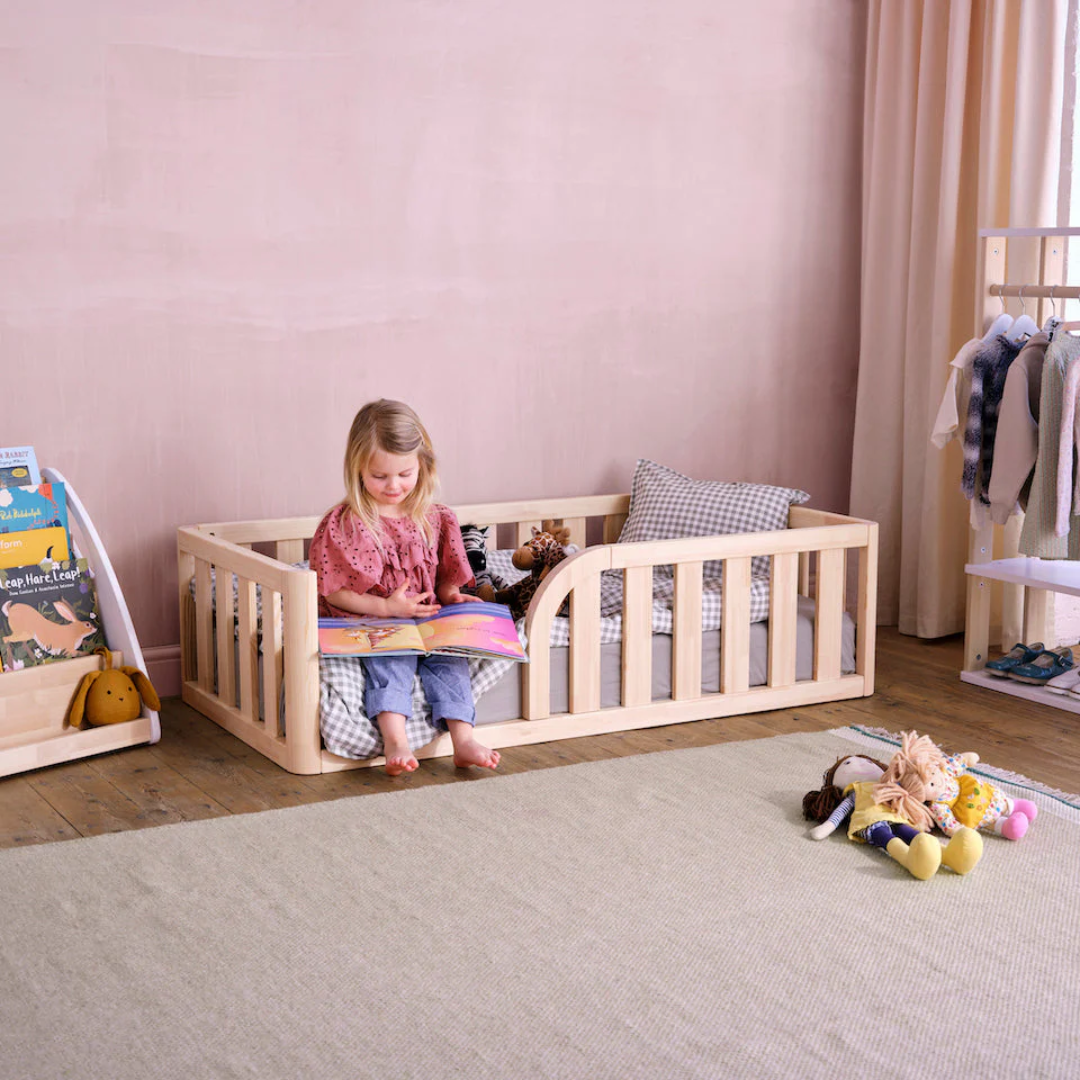 Colorful toddler floor bed with Montessori-style decor in a cozy nursery setting.